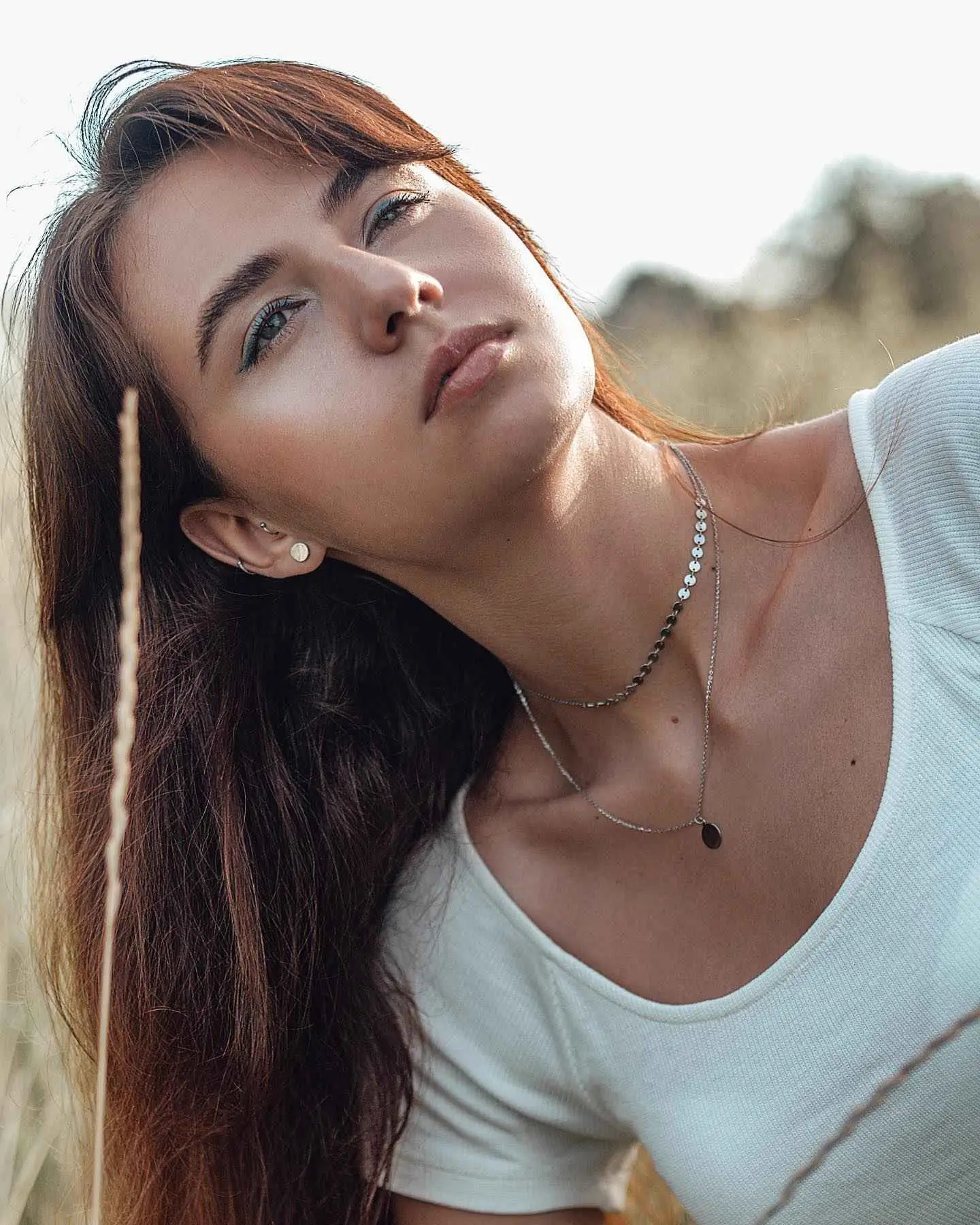 Girl standing in the field looking in the sky